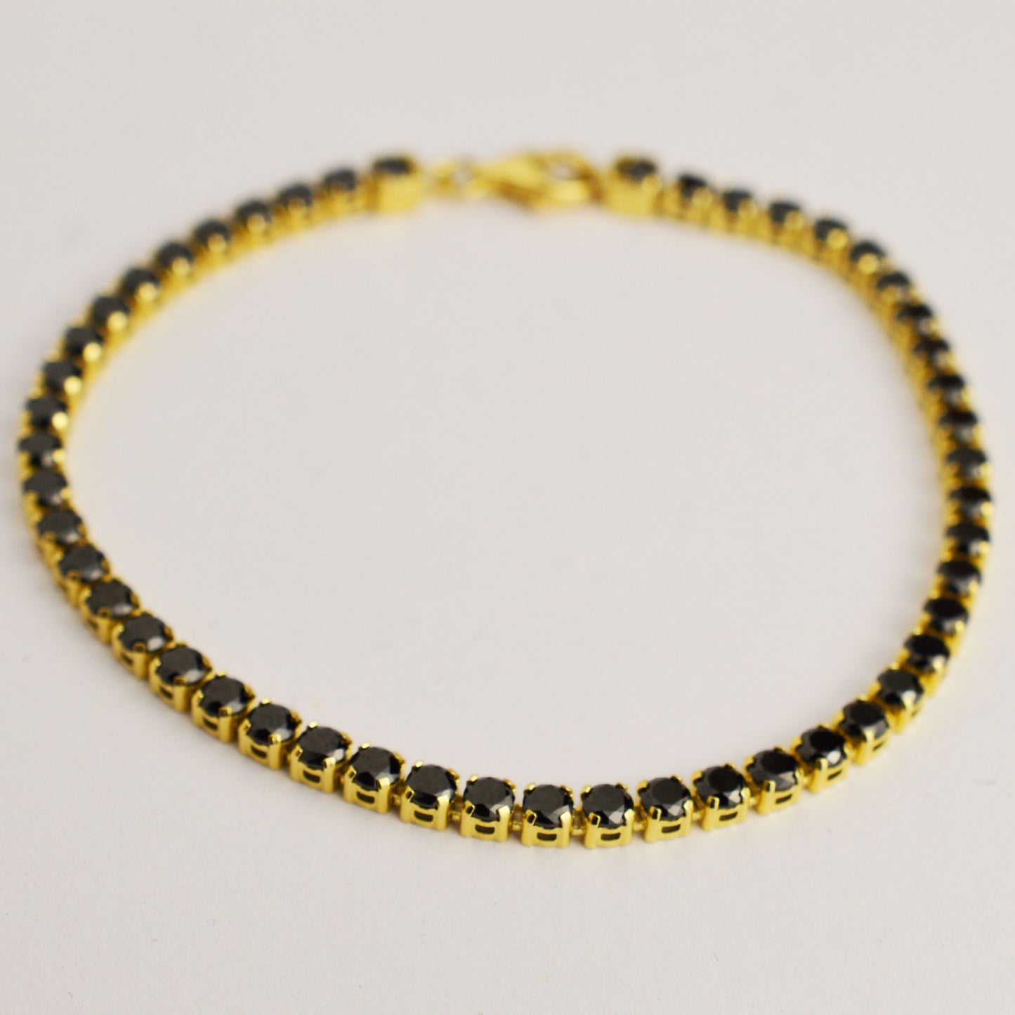 Gold tennis bracelet with black large stones